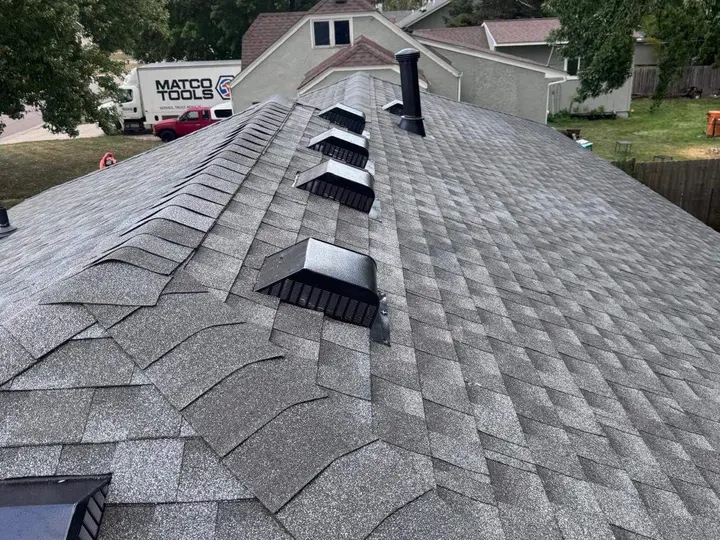 Architectural shingle ridge with a row of roof vents