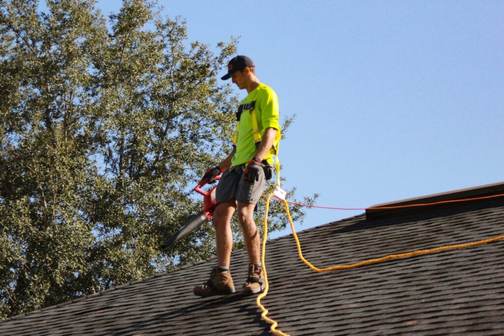 Professional roofer installing asphalt shingles on residential roof