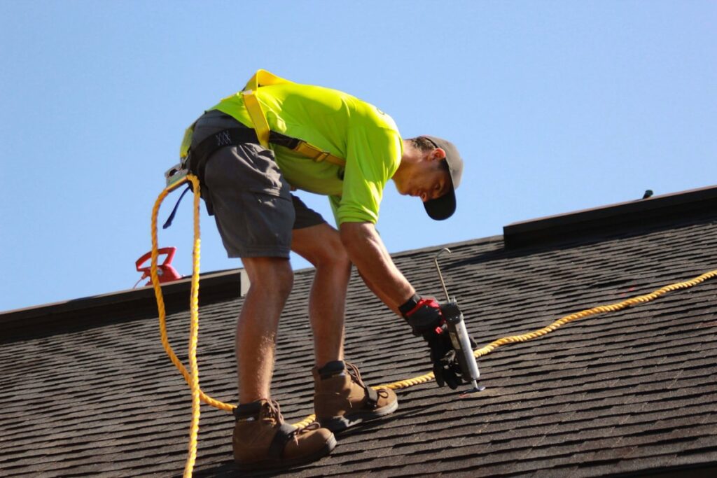 Roofer using power drill for roof repair work